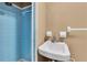 Compact bathroom features a walk-in blue tiled shower and a white sink at 7037 Green St, New Port Richey, FL 34652