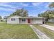 Charming single story home featuring a well maintained lawn and welcoming red front door at 7037 Green St, New Port Richey, FL 34652