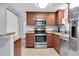 Updated kitchen featuring stainless steel appliances and beautiful cherry wood cabinets at 7037 Green St, New Port Richey, FL 34652