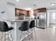 Kitchen with stainless steel appliances, bar seating, and cherry wood cabinets at 7037 Green St, New Port Richey, FL 34652