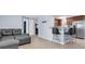 Open-concept living room featuring tile floors, a breakfast bar, and a grey leather sectional at 7037 Green St, New Port Richey, FL 34652