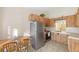 Efficient kitchen featuring wood-style cabinets, stainless steel refrigerator, and a cozy eat-in area at 7650 Forest Trl # 7, Port Richey, FL 34668
