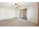 Spacious main bedroom features neutral carpet, a ceiling fan, and sliding glass doors to the lanai at 7650 Forest Trl # 7, Port Richey, FL 34668