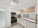 Well-lit kitchen with white cabinets, tiled backsplash, and modern stainless steel appliances, ideal for culinary enthusiasts at 8202 Woodsong Row, Hudson, FL 34667