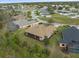 Aerial view of the home with a screened lanai, lush landscaping, and circular street at 8373 Maybelle Dr, Weeki Wachee, FL 34613