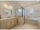 An elegant bathroom featuring a soaking tub, glass shower, and vanity with storage at 8373 Maybelle Dr, Weeki Wachee, FL 34613