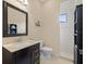 Stylish bathroom features a dark vanity with marble countertop and a tiled walk-in shower at 8373 Maybelle Dr, Weeki Wachee, FL 34613