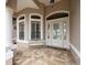 Inviting front porch with a bench and beautiful entryway, showcasing a light-colored brick floor at 8373 Maybelle Dr, Weeki Wachee, FL 34613