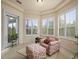 Comfortable sitting area featuring an armchair, ottoman, and an abundance of natural light from large windows at 8373 Maybelle Dr, Weeki Wachee, FL 34613