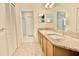 Bathroom featuring double sinks, granite countertops, wood cabinets, and glass-enclosed shower at 9634 Green Needle Dr, New Port Richey, FL 34655