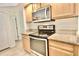 Modern kitchen features stainless steel appliances, wooden cabinetry and granite countertops at 9634 Green Needle Dr, New Port Richey, FL 34655