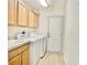 Functional laundry room features washer, dryer, utility sink, and ample cabinetry at 9634 Green Needle Dr, New Port Richey, FL 34655
