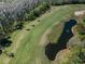 An aerial view features a lush green golf course, a serene pond, and vibrant landscaping from above at 9713 Sweeping View Dr, New Port Richey, FL 34655