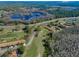 An aerial view of a community showcases golf course views, a pond, and a tranquil natural landscape at 9713 Sweeping View Dr, New Port Richey, FL 34655
