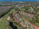 Panoramic aerial view of a lovely community, a golf course, and a serene pond with a fountain at 9713 Sweeping View Dr, New Port Richey, FL 34655