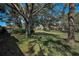 Spacious backyard with lush lawn and mature trees, providing a serene outdoor space with a house view at 9713 Sweeping View Dr, New Port Richey, FL 34655