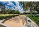 Bocce ball court with a tennis court in the background and trees in the landscape at 9713 Sweeping View Dr, New Port Richey, FL 34655