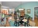 Open dining area with hardwood floors, glass table, access to living room, and stylish decor at 9713 Sweeping View Dr, New Port Richey, FL 34655