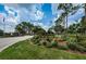 Landscaped entrance to Timber Greens, showcasing colorful flowers, mature trees, and a welcoming sign at 9713 Sweeping View Dr, New Port Richey, FL 34655