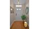 Welcoming foyer with hardwood floors, decorative wall art, and a lush fern, creating a warm entrance at 9713 Sweeping View Dr, New Port Richey, FL 34655