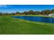 View of the lush green golf course with a lake and trees surrounded by neighborhood homes at 9713 Sweeping View Dr, New Port Richey, FL 34655
