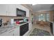 Bright kitchen featuring granite counters, stainless steel appliances, white cabinets, and breakfast nook at 9713 Sweeping View Dr, New Port Richey, FL 34655
