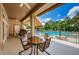 Relaxing poolside patio with outdoor seating, a ceiling fan, and an awning for shade, perfect for leisure at 9713 Sweeping View Dr, New Port Richey, FL 34655
