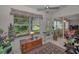 Bright sunroom with tile floor, large windows, ceiling fan, and comfortable seating area at 9713 Sweeping View Dr, New Port Richey, FL 34655