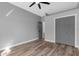 A bedroom featuring wood-look flooring, a ceiling fan, a closet, and neutral paint at 10379 Golden Ave, Brooksville, FL 34613