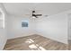 Bright bedroom features wood-look floors, a ceiling fan, and a window for natural light at 10841 Scenic Dr, Port Richey, FL 34668