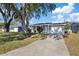 Charming single-story home with a well-manicured lawn, gray paint, white trim and an attached garage at 10841 Scenic Dr, Port Richey, FL 34668