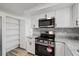 Modern kitchen featuring stainless appliances, granite counters, and white cabinets at 10841 Scenic Dr, Port Richey, FL 34668