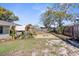 Backyard with grass and dirt and a gravel fire pit area and a covered patio area at 10938 Water Oak Dr, Port Richey, FL 34668