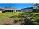 Large backyard featuring well-maintained lawn, the rear of the home, and lush greenery at 11817 Bayonet Ln, New Port Richey, FL 34654