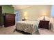 Bedroom with neutral walls, stylish lamps, and dark wood bedroom furniture at 11817 Bayonet Ln, New Port Richey, FL 34654