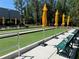 Well-maintained bocce ball court with yellow shade umbrellas and benches, perfect for outdoor recreation at 11817 Bayonet Ln, New Port Richey, FL 34654