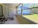 Enclosed sunroom with tiled flooring offering an view of a blue home's exterior at 11817 Bayonet Ln, New Port Richey, FL 34654