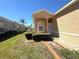 Home's front entrance features manicured landscaping, attractive trim, and a decorative arched window above the door at 12151 Putter Green Ct, New Port Richey, FL 34654