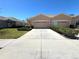 Charming single-story home featuring a well-manicured lawn and a long driveway leading to the garage at 12151 Putter Green Ct, New Port Richey, FL 34654