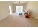 Bright living room with a ceiling fan, sliding glass doors, and neutral carpet at 12151 Putter Green Ct, New Port Richey, FL 34654