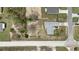 A clear aerial view of a single-story house with a gray roof, surrounded by sandy terrain and trees at 13140 Maycrest Ave, Weeki Wachee, FL 34614