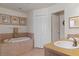 Bathroom with a soaking tub, tile surround, and dual sinks, offering a relaxing and functional space at 13140 Maycrest Ave, Weeki Wachee, FL 34614