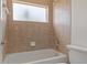 Bathroom showcasing a bath tub with tiled walls and frosted window at 13140 Maycrest Ave, Weeki Wachee, FL 34614
