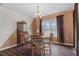 Traditional dining area with wood table, chairs, and cabinet, illuminated by a chandelier and natural light at 13140 Maycrest Ave, Weeki Wachee, FL 34614