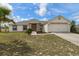 Inviting single-story home with a two-car garage and a well-maintained front yard at 13140 Maycrest Ave, Weeki Wachee, FL 34614