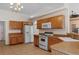 Open kitchen with wood cabinets, white appliances, and tile flooring at 13140 Maycrest Ave, Weeki Wachee, FL 34614