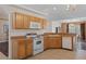 Functional kitchen with wood cabinets, white appliances, and tile flooring at 13140 Maycrest Ave, Weeki Wachee, FL 34614