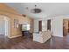 Comfortable living room with dark laminate flooring, a ceiling fan, and natural light at 13140 Maycrest Ave, Weeki Wachee, FL 34614