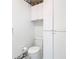 Bathroom featuring a white toilet, white storage cabinets, and decorative wallpaper at 13227 Molitor Ct, Hudson, FL 34669