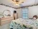 Cozy bedroom with a decorative ceiling fan, large window, and a floral patterned quilt at 13227 Molitor Ct, Hudson, FL 34669